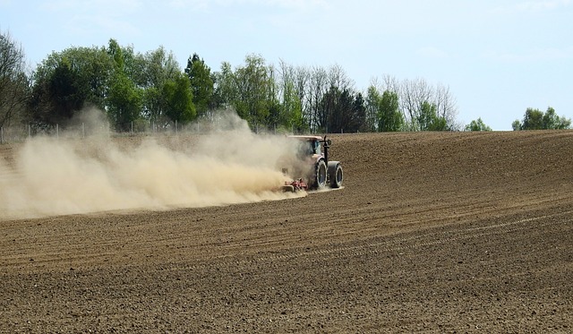 Ein Traktor bearbeitet während einer Dürre ein Feld
